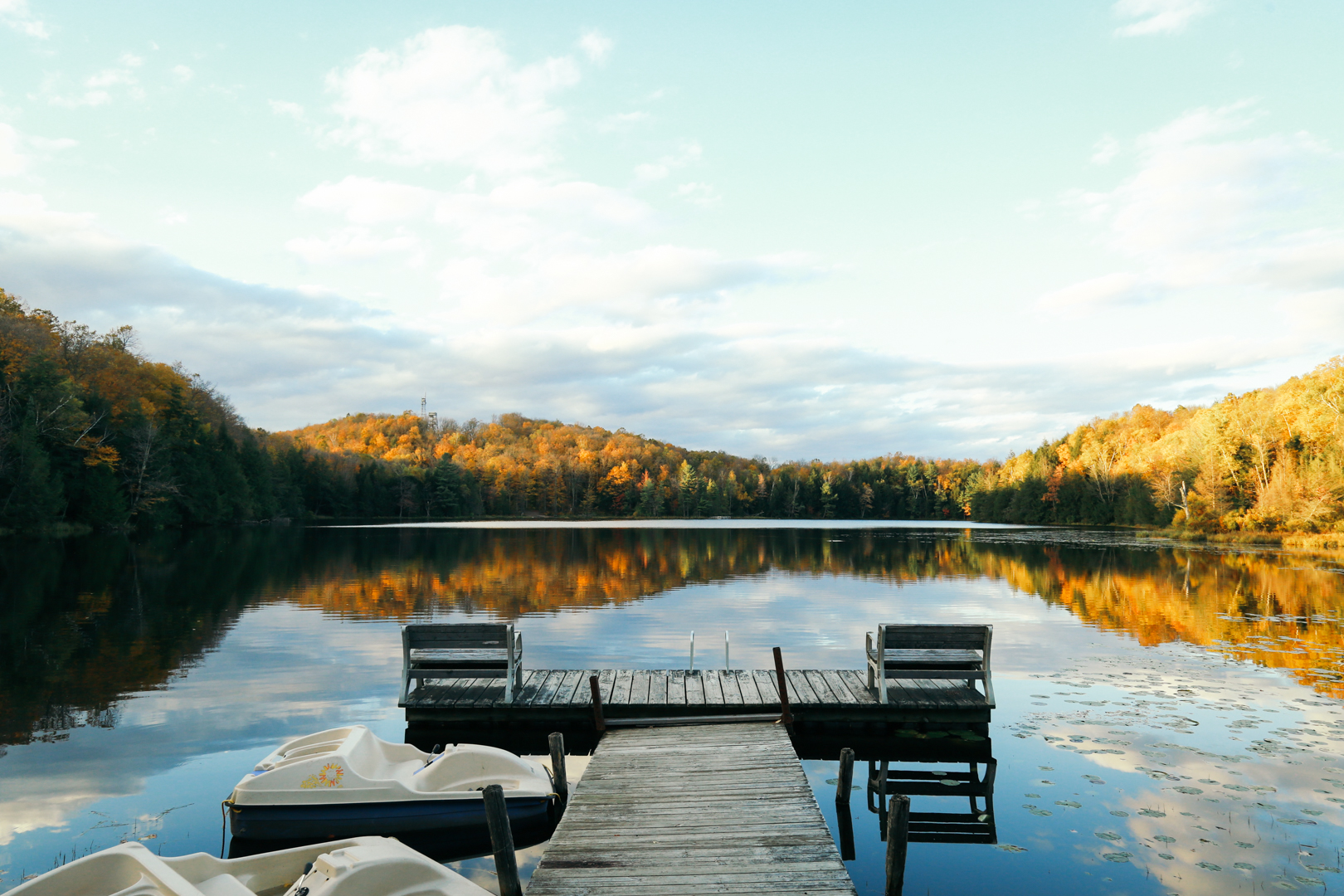 dock on glass like lake with fall colors in wisconsin